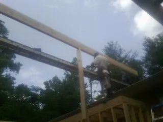 Carpenter setting a ridge beam over a new addition frame — Ice Dam Removal by Roofing Brothers in Mont Alto